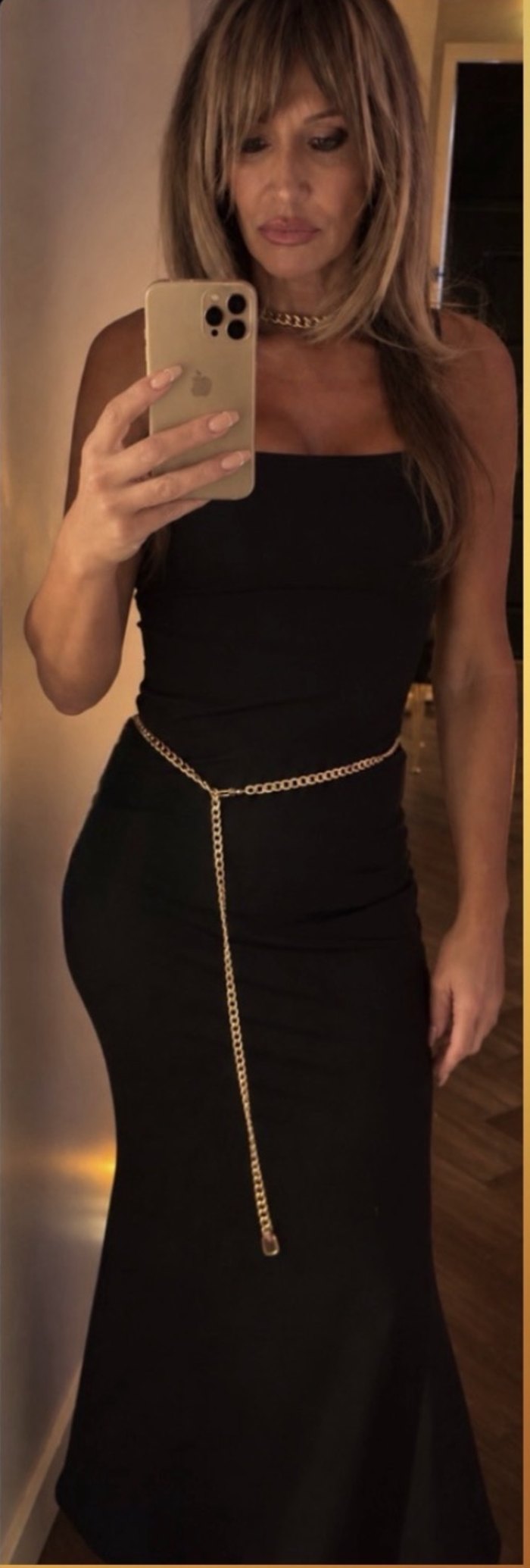Armanda in a black gown with a gold chain belt